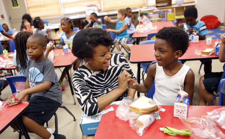 Kam works with children attending summer camp at Commo Community Center in Fort Worth.